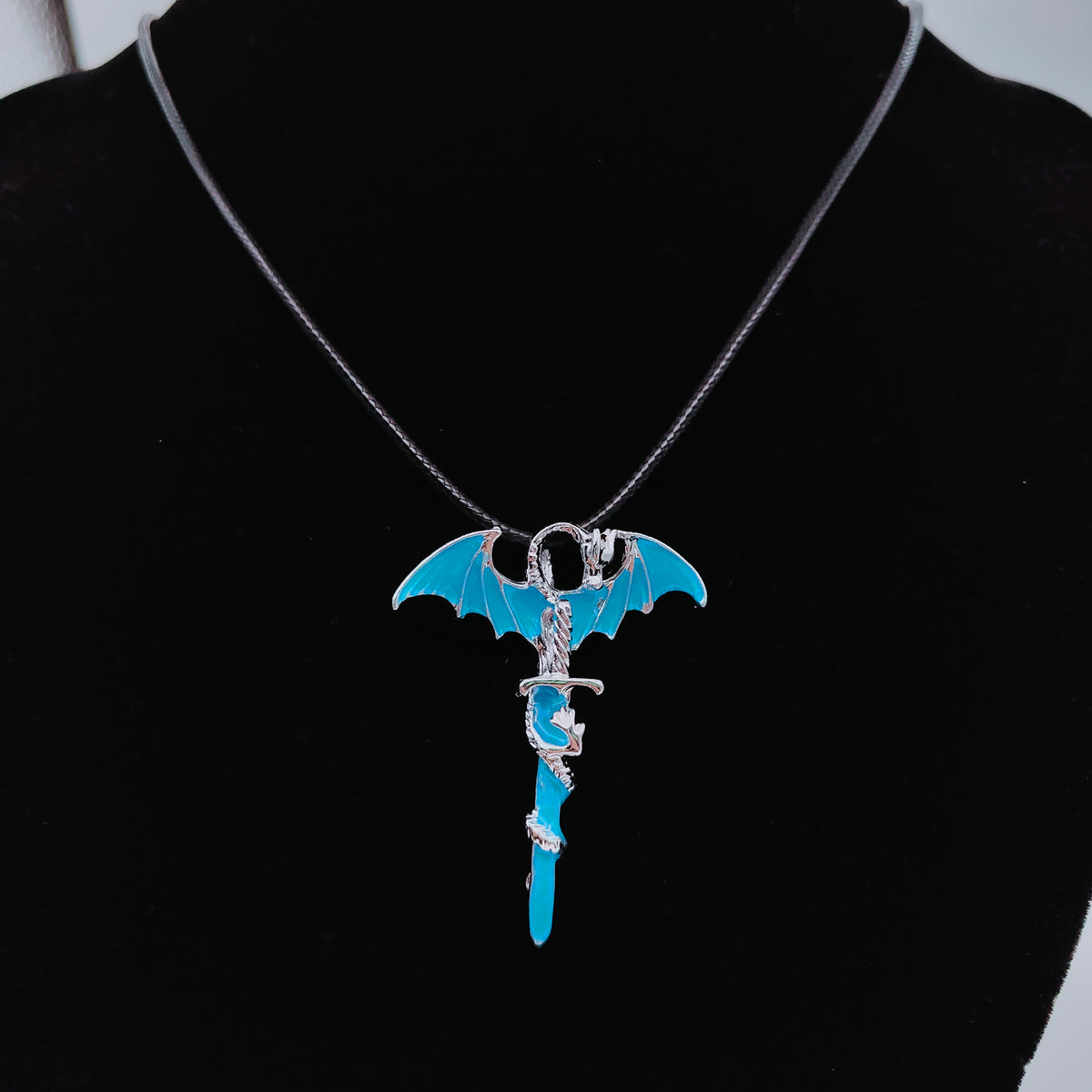 Blue Dragon sword necklaces displayed together on black jewellery bust