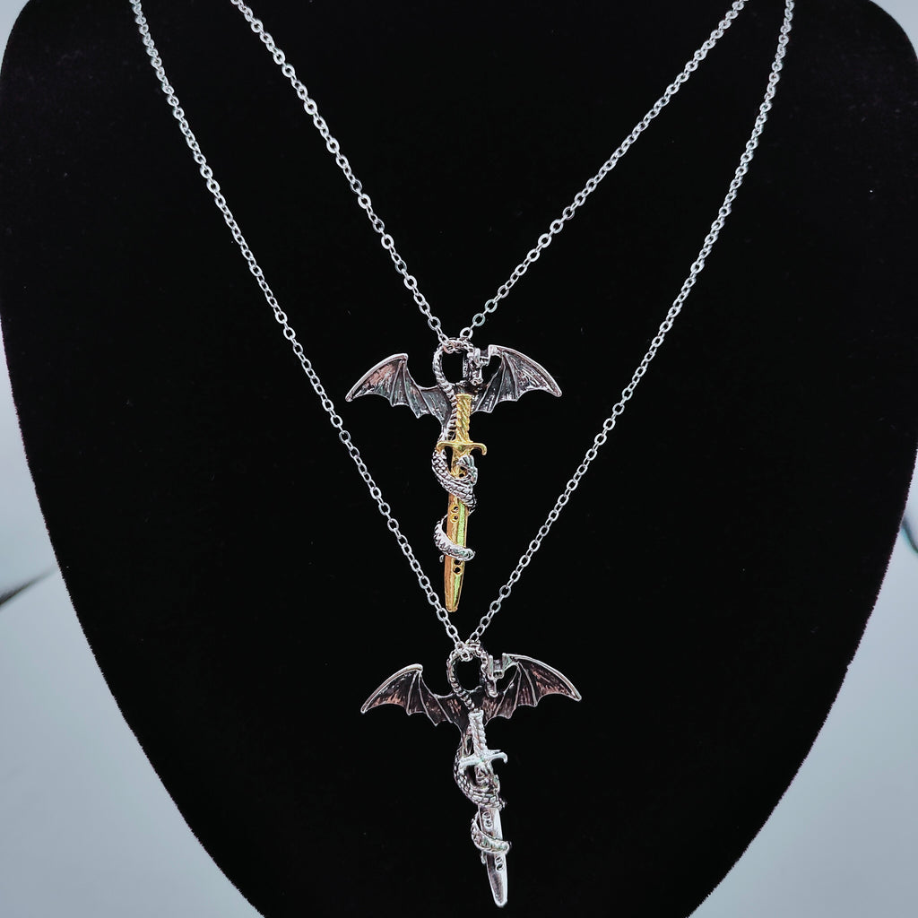 Gold and silver dragon sword necklaces displayed together