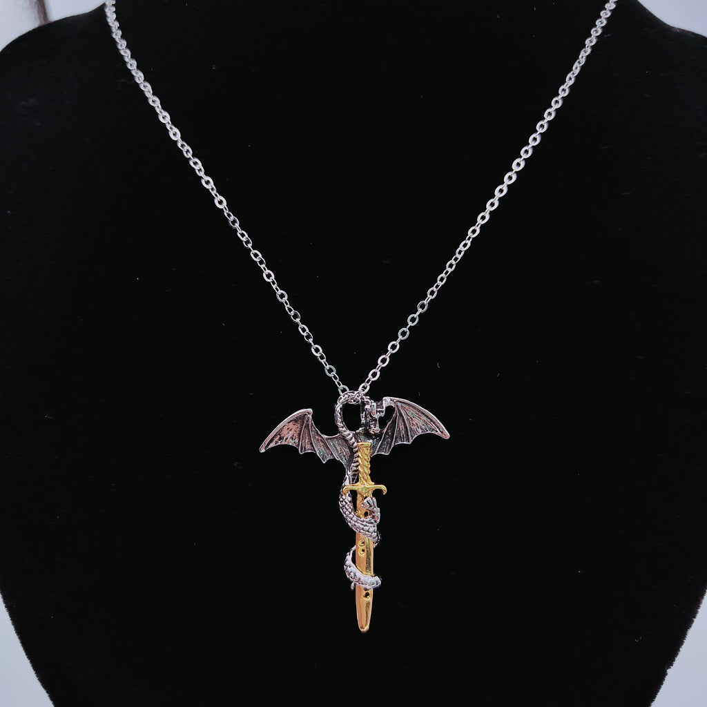 Gold-tone dragon sword pendant necklace displayed on black jewellery bust