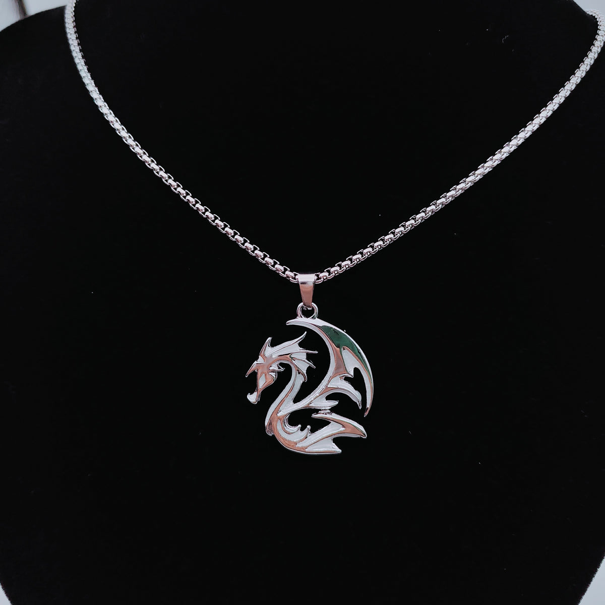 Pale silver-tone tribal dragon pendant necklace displayed on black bust
