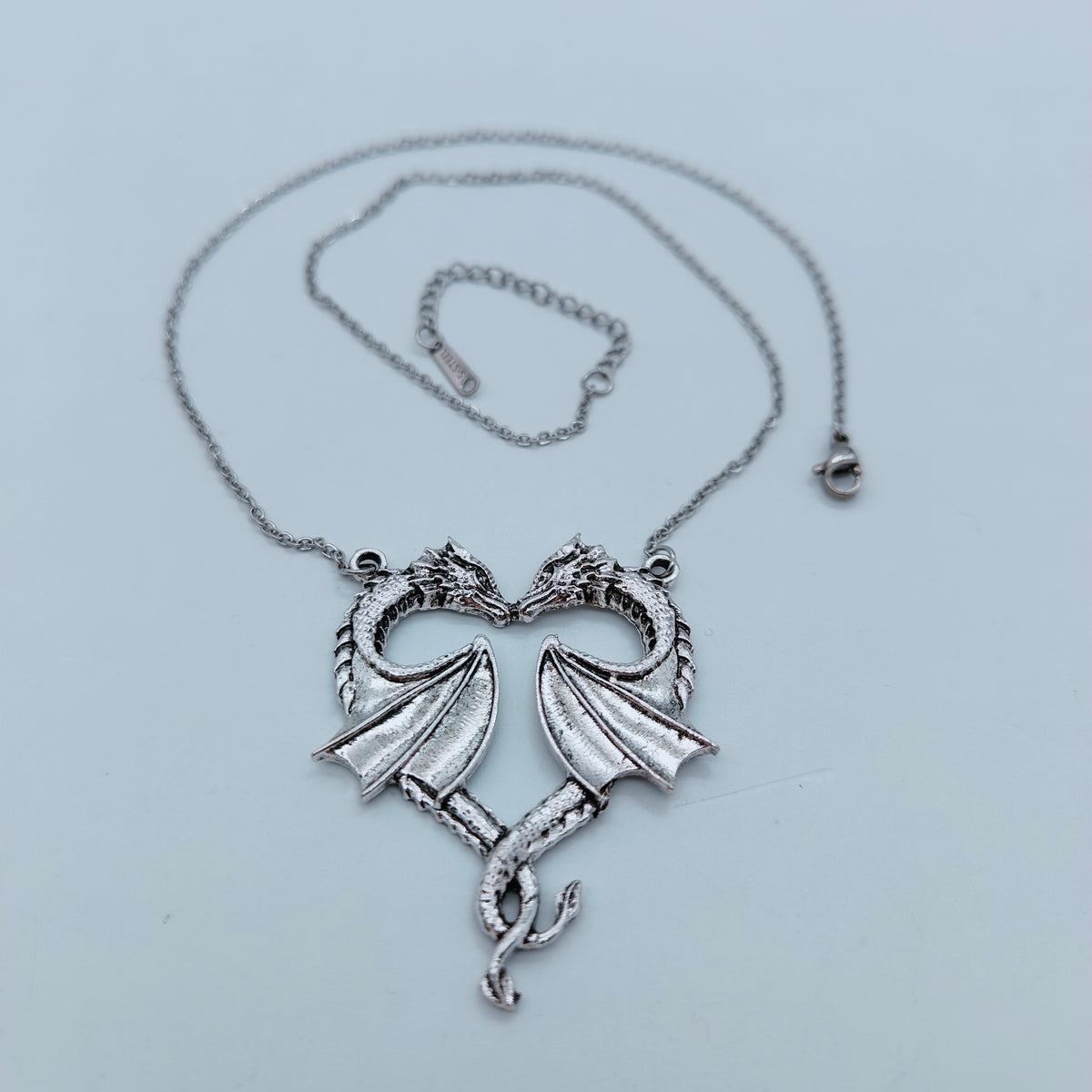 Silver-tone twin dragon heart pendant with matching chain and adjustable clasp