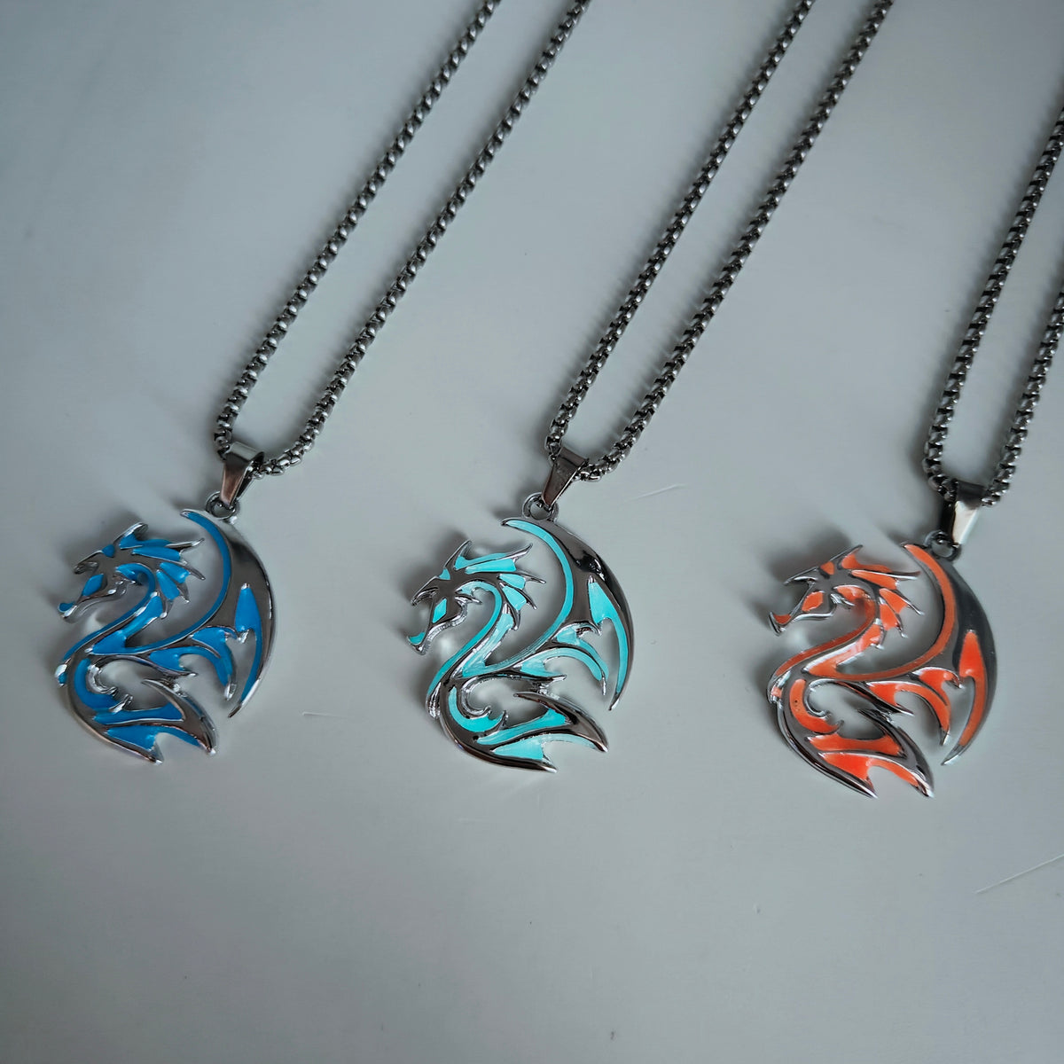 Glow in the dark tribal dragon necklaces in blue, light blue and flame orange