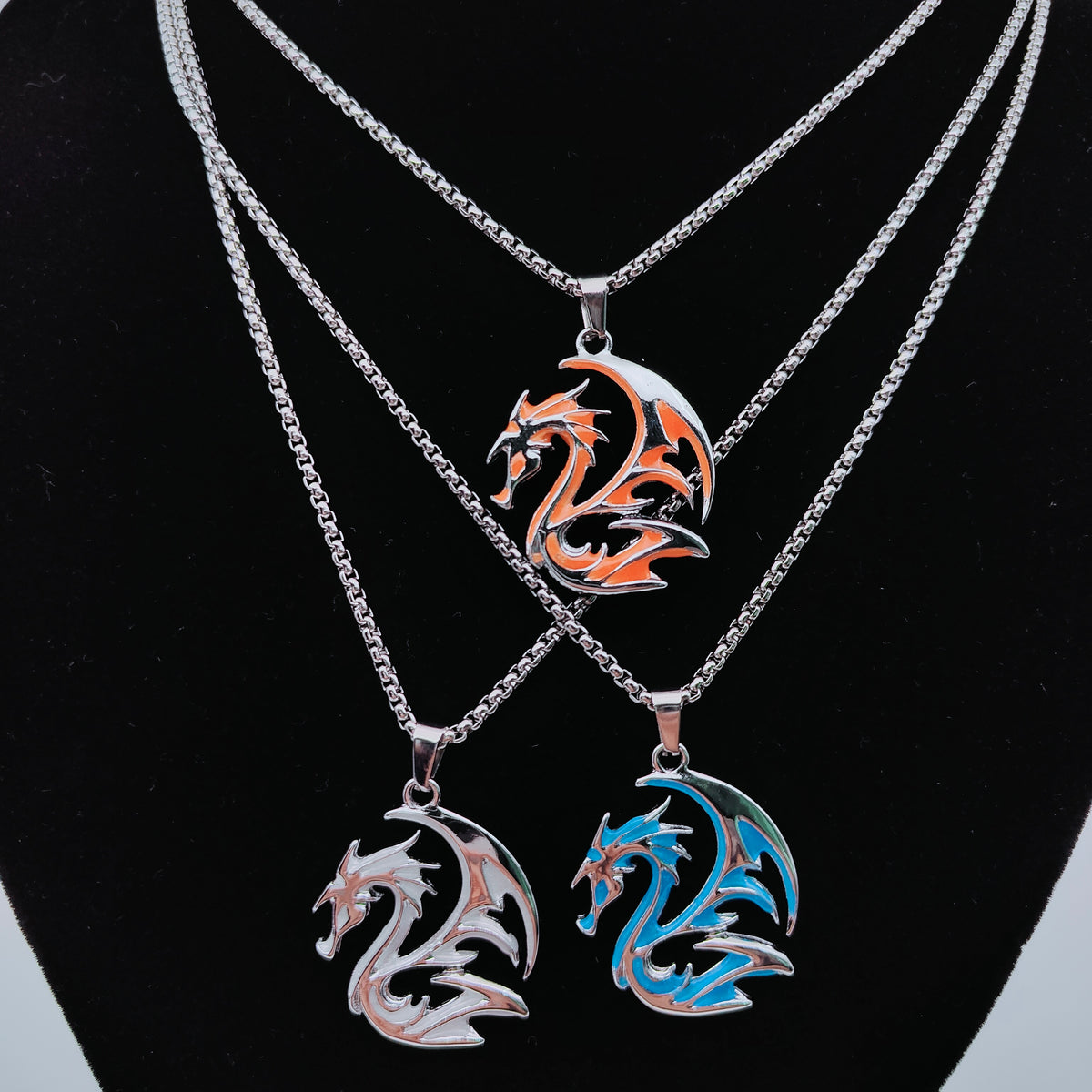 Three tribal dragon necklaces displayed against black jewellery bust