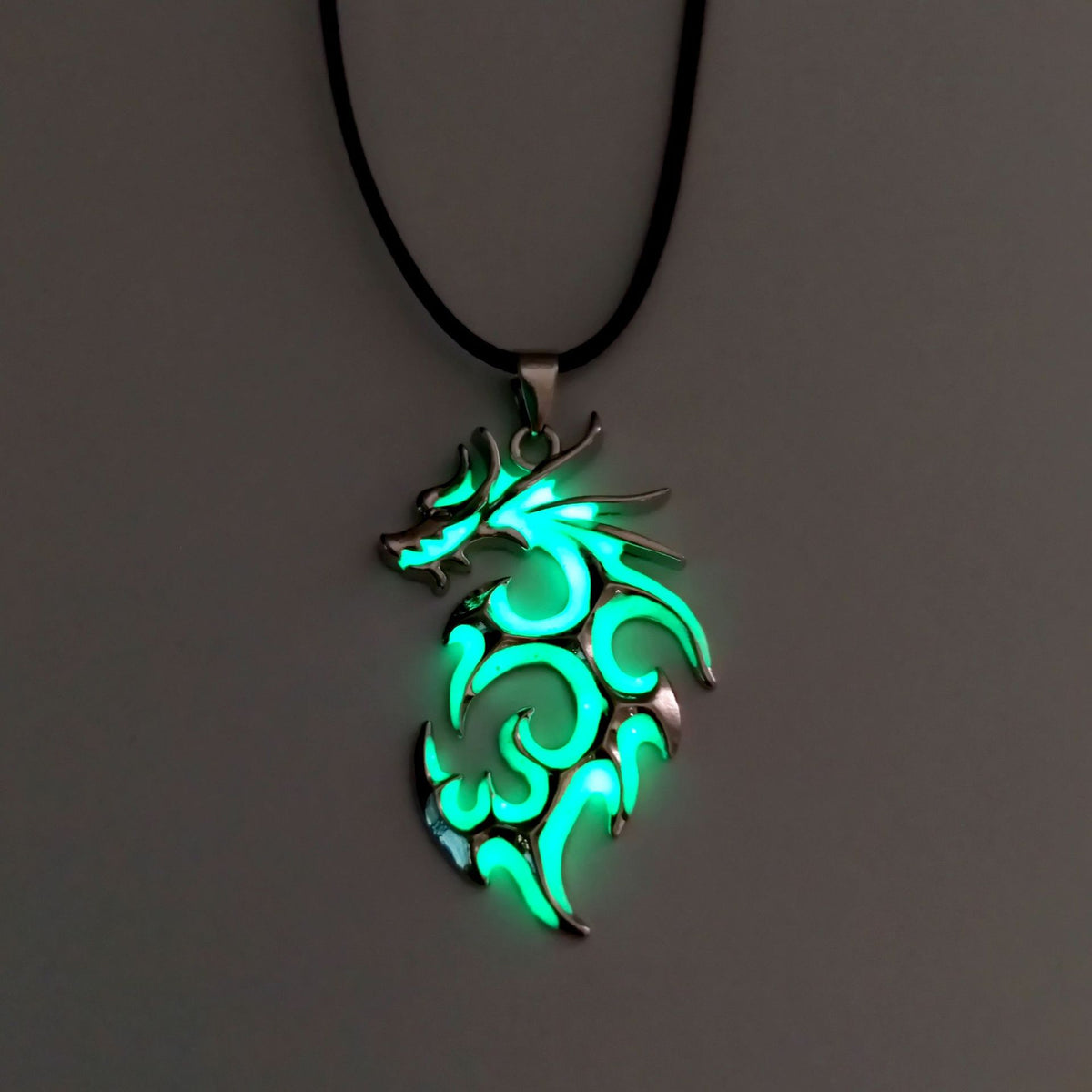 Green tribal flame dragon necklace featuring intricate swirling dragon design