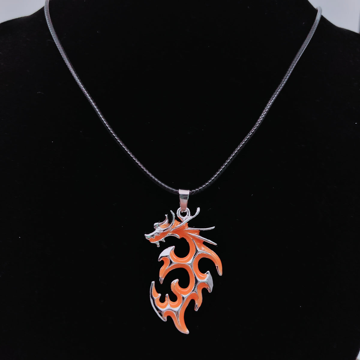 Orange tribal flame dragon necklace featuring intricate swirling dragon design